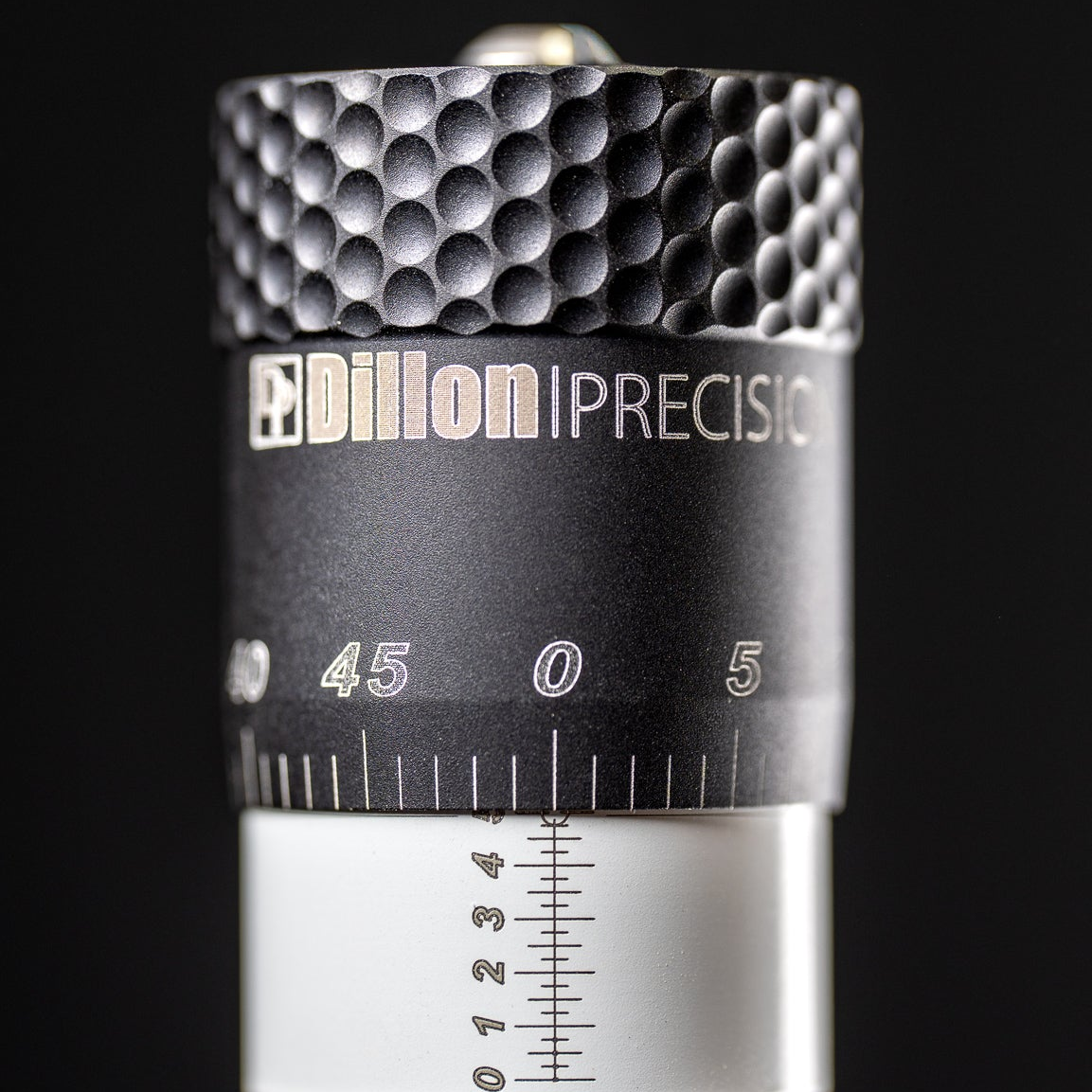 Close-up of the knurled micrometer head, the Dillon Precision wordmark, and the graduated dial and vernier scale.